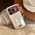 Close-up of cream iPhone case with colorful star patterns and purple glitter accent. - Pearl White Gilded Brown Star / 17Promax