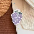 Gros plan d'un support de téléphone en forme de raisin violet sur une coque beige - Support Raisin au Plomb Violet / Support Unique