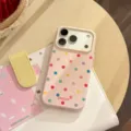 Primo piano di una custodia per iPhone rosa con pois colorati su una scrivania. - Per iPhone 17 Pro Max / Rosa Bacca Caramella