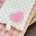 Vue macro d'un support de téléphone extensible rose brillant en forme de cœur poli - Support Cœur Rose