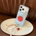 Détail de la coque de téléphone à rayures bleues avec motif pomme et breloque perlée - Pomme Rouge à Rayures Bleues Brillantes Avec Chaîne Étoile / iPhone 17 Pro Max