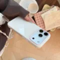 Vue détaillée d'une coque iPhone blanche avec bordure rose clair et logo 'BonneCase' - Blanc Poire (Texte Blé)