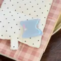 Détail macro d'un support de téléphone géométrique bleu sur un fond à carreaux rose - Support Demi-Cercle Bleu