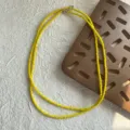 Makro-Detailansicht kleiner facettierter gelber Spinell-Perlen an einer Halskette - 4,3 mm Perlendurchmesser / Gelb