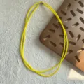 Dettaglio macro di una collana a due strati di perline di spinello giallo brillante. - Diametro Perla 3,7mm / Giallo