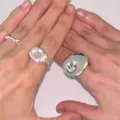 Nahaufnahme minimalistischer glänzender Silberringe an Händen mit Strukturfinish - Glatter Silberner Ring