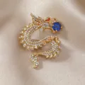 Exquisite luxuriöse Retro-Drachenbrosche mit blauem Edelstein und funkelnden Kristallen - Goldener Drache mit blauer Perle
