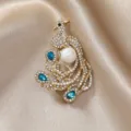 Luxuriöse Vintage-Pfau-Brosche mit Perle und Kristallen auf Seidenhintergrund - Phönix mit blauen Steinen