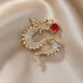 Vintage goldener Drachenbrosche mit schimmernden Strasssteinen und großem roten Kristall. - Goldener Drache mit roter Perle