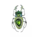 Macro detail of a vintage beetle brooch featuring vibrant green crystals and silver metal - Green