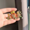 Sparkling crystal owl family brooch with intricate rhinestone details on a green branch - Three Owls Brooch (XZ0457-3) / Champagne