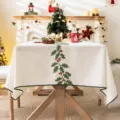 Elegante mantel navideño con bordado de acebo y bayas rojas para cenas festivas - Borde verde