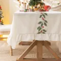 Mantel de Navidad de lino blanco con bordado de acebo festivo y elegantes volantes. - Borde con Volantes