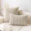 Cream white vertical striped faux fur pillowcases on a modern sofa - Sand