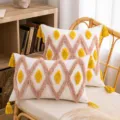 Federa per cuscino boho trapuntata con motivi rosa e nappe gialle su sedia - Tramonto