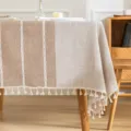 Mantel impermeable de estilo nórdico con elegantes borlas sobre una mesa de madera - 60*60cm / Beige Café