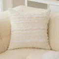 Funda de cojín boho crema con rayas de flecos en un sofá de lana de oveja sintética - Flor de Esquila Beige