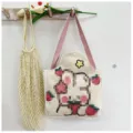 Detalle de una bolsa de lona de conejo colgada en un gancho de madera de pared. - Estilo 4 (Conejo Fresa)