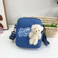 Primer plano del adorable osito de peluche blanco en un mini bolso bandolera de nailon azul - 16*20*6 / Azul