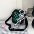 Detalle de bolso bandolera negro con cuadros verdes y un adorable accesorio de conejo - 16*20*6 / Negro