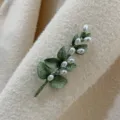 Detail view of a vintage Baroque style brooch with green leaves and white pearls - Eucalyptus