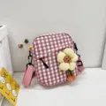 Primer plano del bolso bandolera a cuadros rosa con un gran adorno decorativo de flor amarilla - 16*18*6 / Rosa