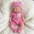 Detailansicht einer 13-Zoll Silikon-Reborn-Babypuppe in einem rosa Strickstrampler-Set - 13 Zoll / Rosa Jumpsuit-Stil