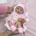 Detailed view of a 16-inch lifelike silicone baby doll wearing a pink bear-print suit. - Pink Bear Style / 16inch