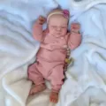 Nahaufnahme einer realistischen 19-Zoll Reborn-Puppe in einem rosa Strickoutfit - Vollsilikon-Stil / Rosa