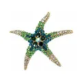 Macrodetail van de kleurrijke kristallen pavé-zetting op een gouden zeesterbroche - Groen