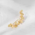 Detaillierte Nahaufnahme einer goldenen Schmetterlingsbrosche mit edler Perle - Gold