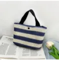 Stylish blue and white striped woven straw handbag displayed on an open magazine - 30*18*12cm / Blue