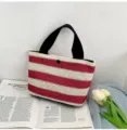Casual striped woven straw handbag with black handles on an open book with tulips - 30*18*12cm / Red
