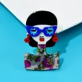Vista detallada de un elegante broche de acrílico con gafas azules y vestido de flores - Chica Moderna (R0-4-7406)