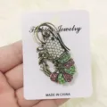 Detailopname van een vintage bronzen kreeftspeld met sprankelende kleurrijke strass. - Groen