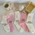 Close-up of pink and white mid-calf socks with cute bow, heart, and cable knit details. - One Size / Cable Knit Pink White