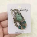 Vintage kreeft broche accessoire met groene en gouden kristallen strass op witte kaart - Blauw