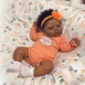 19 inch reborn baby doll with dark skin wearing orange striped onesie and headband - 48cm Cloth Body / As Shown