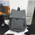 Gray large capacity water-repellent backpack with flap lid and side pockets on desk - Gray