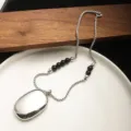 Close-up of minimalist silver necklace with black onyx beads and mirror pendant - Black Agate Beaded Necklace