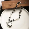 Detailansicht einer Halskette mit silbernem Anhänger, schwarzen Perlen und Perlen. - Schwarze Achatkette (Kieselanhänger)