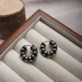 Detailed view of vintage silver hoop earrings with black enamel sections in a display tray - Black Silver