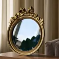 Detail showing vintage gold bow tie frame of the elegant round tabletop decorative mirror - L / 15.3x18x2cm / Gold