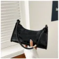 Chic black croc-embossed underarm bag for women, stylish minimalist baguette style. - Black