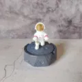 Detailed shot of resin astronaut figurine on moon surface base for modern desktop decor. - 10x10x9cm / Gold