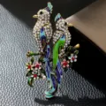 Detailed view of elegant enamel bird brooch featuring sparkling rhinestones and flowers. - Gold White