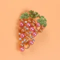 Detailed view of elegant grape brooch with pink pearls and green crystal leaf accents - Pink Gold Grape Brooch