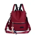 Close-up detail of burgundy Oxford cloth anti-theft backpack with cute cat charm attachment - Red (No Pendant)