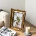 Ornate vintage gold relief photo frame with floral art on a stylish wooden table - Outer 13.5*18.5CM
