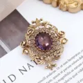 Nahaufnahme einer antiken Goldbrosche mit einem eleganten violetten Edelstein - Lila Strass Barockstil